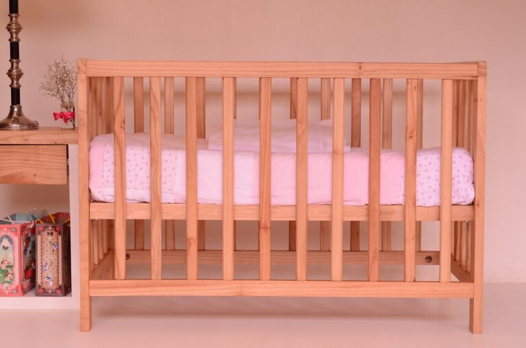 Side view of empty baby crib in a bedroom setting