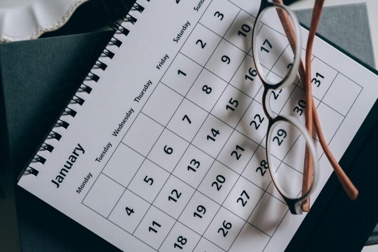 A January calendar with eyeglasses on a table, emphasizing planning and organization.